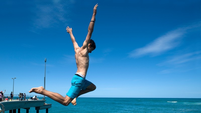 Muž skáče do mora_vypracované telo_ilustrák